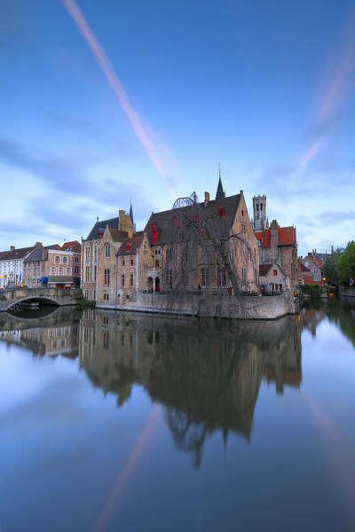 The medieval Belfry and historic buildings are reflected in Rozenhoedkaai canal at dawn Bruges West Flanders Belgium Europe