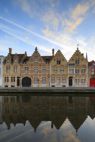Bright sky at dawn on historic buildings of the city centre reflected in the typical canal Bruges West Flanders Belgium Europe