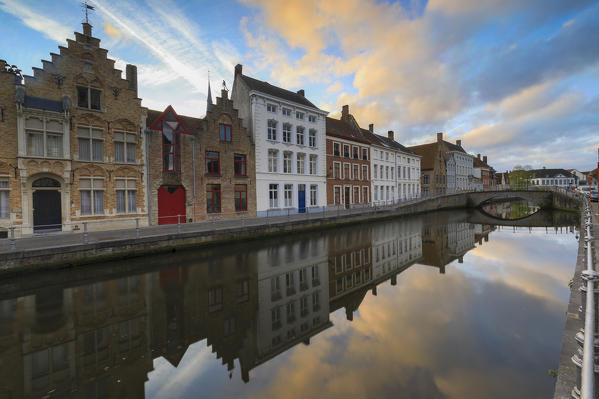 Clouds at dawn on typical buildings and bridges of city centre reflected in the canal Bruges West Flanders Belgium Europe