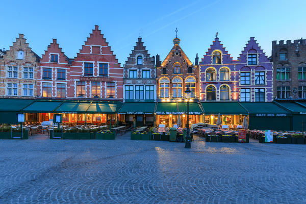 Blue lights of dusk on the colorful medieval houses in Market Square Bruges West Flanders Belgium Europe