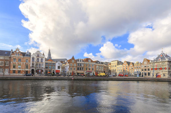 Clouds are reflected in the canal of the river Spaarne framed by typical houses Haarlem North Holland The Netherlands Europe