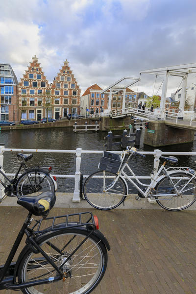Bicycles on quay of canal of River Spaarne with typical houses on the background Haarlem North Holland The Netherlands Europe