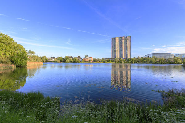 Skyscraper reflected in water seen from a boat trip along the canals of Copenhagen, Denmark