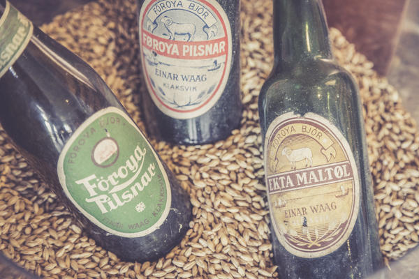 Close up of beer bottles on cereal grain background in the Foroya Bjor family brewery, Klaksvik, Bordoy Island, Faroe Islands