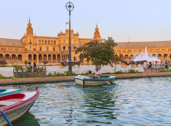 Rowing boat along the canal and horse carriage, the major attractions for tourists, Plaza de Espana, Seville, Andalusia, Spain
