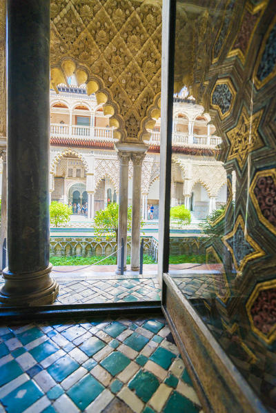 View of Patio de las Doncellas from interior of a room with ancient arabic mosaic flooring and ornate archways, Real Alcazar, Seville, Andalusia, Spain