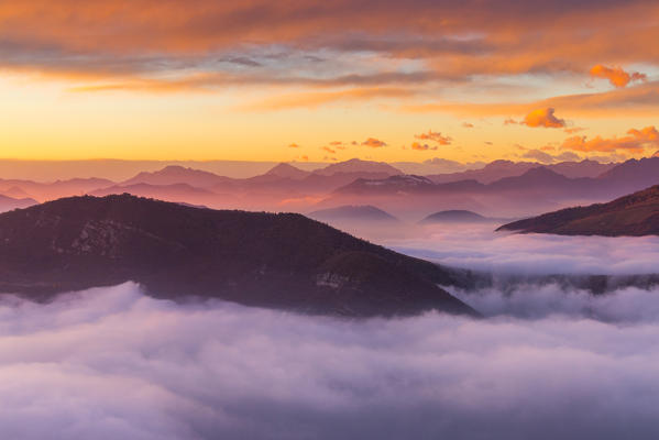 The sunset above the clouds over Prealpi Orobiche. Bronzone Mount (Prealpi Orobiche). Viadanica, Bergamo province, Lombardy, Italy, Europe
