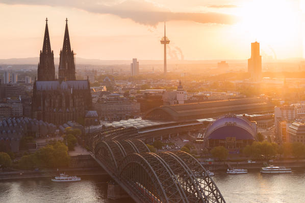 Cologne Cathedral at sunset and Hohenzoller Bridge over River Rhine in Cologne city. Cologne city (Koln), North Rhine Westphalia, Germany, Europe. 