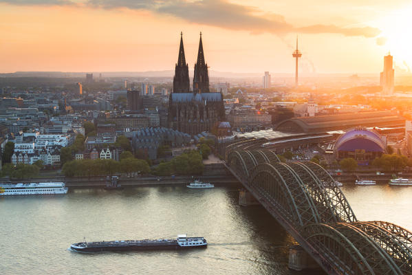Cologne Cathedral at sunset and Hohenzoller Bridge over River Rhine in Cologne city. Cologne city (Koln), North Rhine Westphalia, Germany, Europe. 