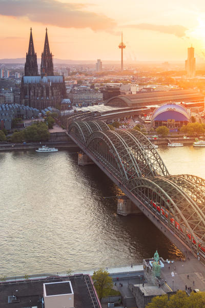 Hohenzoller Bridge over River Rhine and Cologne Cathedral at sunset in Cologne city. Cologne city (Koln), North Rhine Westphalia, Germany, Europe. 