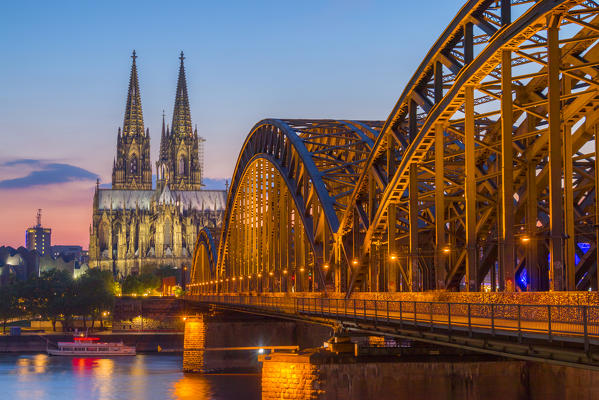 Hohenzoller Bridge over River Rhine and Cologne Cathedral at dusk in Cologne city. Cologne city (Koln), North Rhine Westphalia, Germany, Europe. 