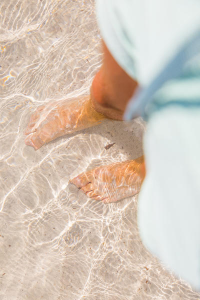 Walking in the crystal turquoise water in Capriccioli beach sea, Arzachena Costa Smeralda, Olbia-Tempio province, Sardinia district, Italy
