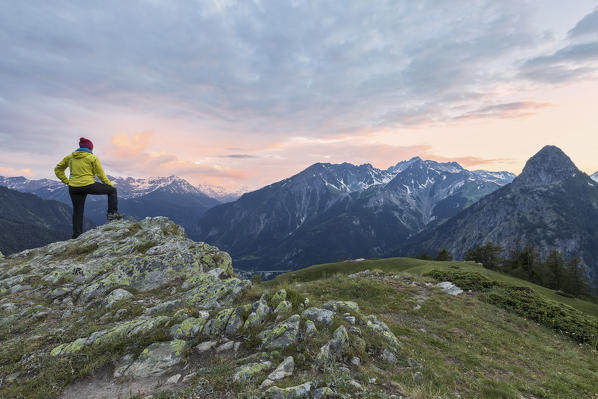 Hiker admire sunset on Mont Chétif, Rifugio Bertone, Courmayeur, Aosta Valley, Italy