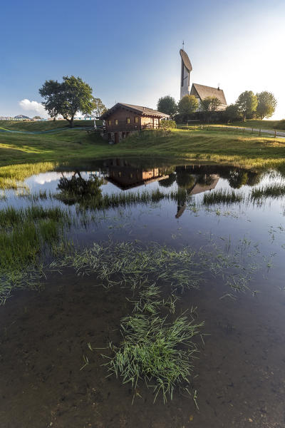 Church and little house relected in a lake at sunset. Italy, Lombardia, Lecco, Pian delle Betulle