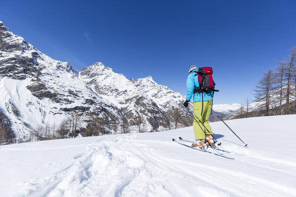 Skier goes down to the bottom valley, Rhemes Notre Dame, Aosta Valley, Italy