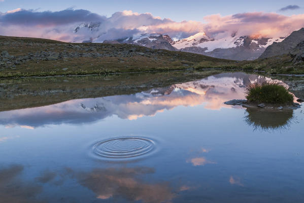 Chain of the Gran Paradiso reflected in an alpine lake at sunset, Valsavarenche, Aosta Valley, Italy