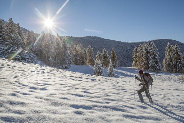 Hiker walks in the snow above La Magdeleine, Aosta Valley, Italy