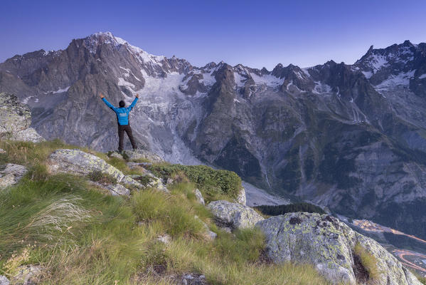 Hiker admires the sunrise on Mont Blanc, Courmayeur, Aosta Valley, Italy