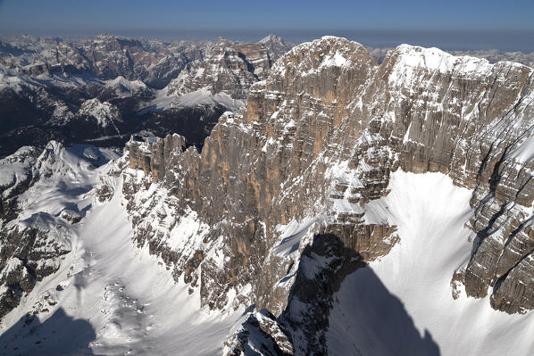 An aerial view of the majestic west side wall with the Tissi and Civetta peaks. Civetta group, 3220masl (10.564ft). Dolomites. Belluno province, Veneto region, Italy, Europe. 

