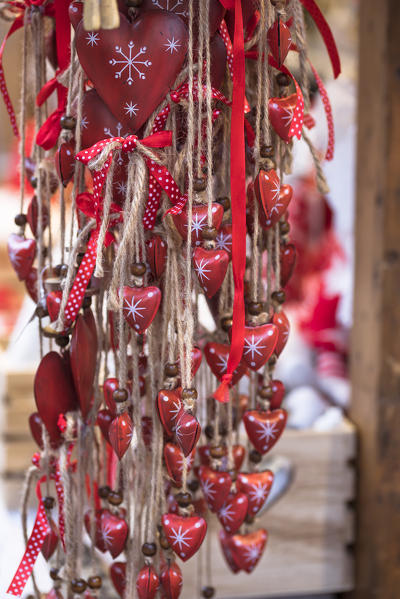 a detail of wood red hearts pendands into the traditional Christmas Markets in South Tyrol, Bolzano province, Trentino Alto Adige, Italy