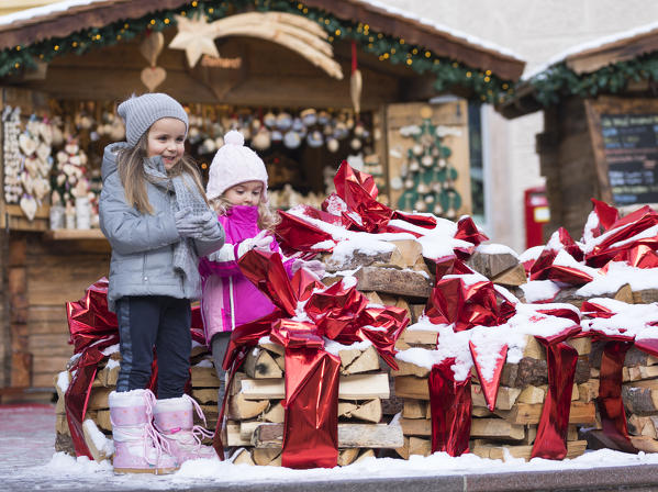 two children stands at the Christmas Market in Val Gardena, Bolzano province, South Tyrol, Trentino Alto Adige, Italy