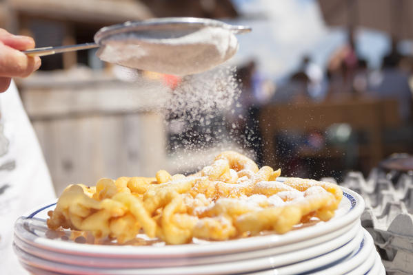 the Strauben: a typical fried dessert covered by icing sugarfrom South Tyrol cooked during a festival. Bolzano province, South Tyrol, Trentino Alto Adige, Italy, Europe 