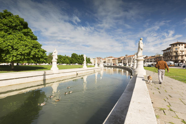 a detail of Prato della Valle, with his typical circular canal and a man with his dog walking around it, padua province, veneto, italy, europe, 