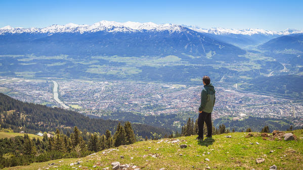 A man staring at the city of Innsbruck from the meadows of Höttinger Alm, Nordkette, Innsbruck, Tyrol, Europe
