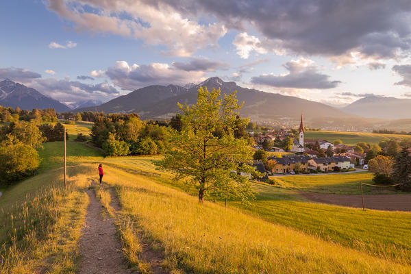 A woman staring at the little village of Vill at sunset with the Saile mountain in the background, Vill, Innsbruck, Tyrol, Austria, Europe