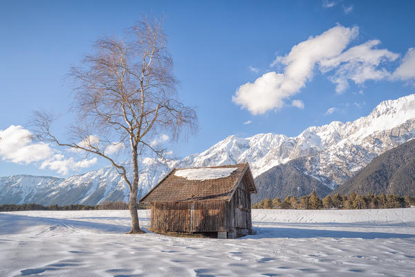 A typical wooden cabin in the snowy fields of Wildermieming, Mieming, Sonnenplateau, Innsbruck Land, Tyrol, Austria, Europe