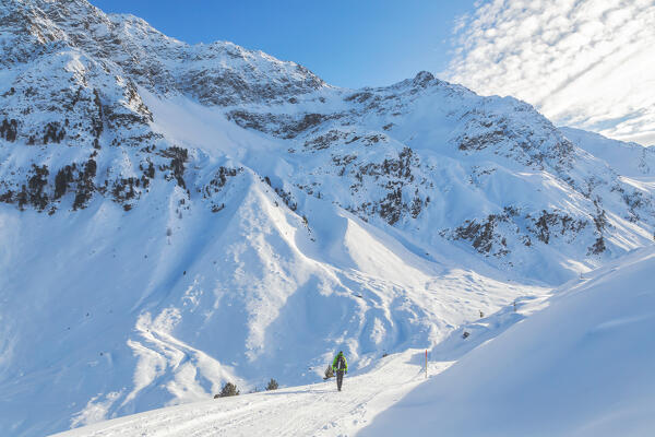 A Mountaineer walking down the Fotsch Valley with Schwarzhorn und Hohe Schöne peaks in the background, Sellrain, Innsbruck Land, Tyrol, Austria, Europe