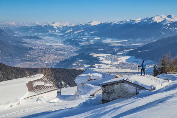 A mountaineer enjoying the view from the roofs of Krimpenbach Alm, Oberperfuss, Innsbruck Land, Tyrol, Austria, Europe