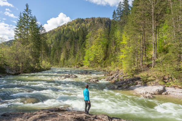 A hiker standing in front of the rapids of Brandenberger Ache, Brandenberg region, Kufstein district, Tyrol, Austria, Europe