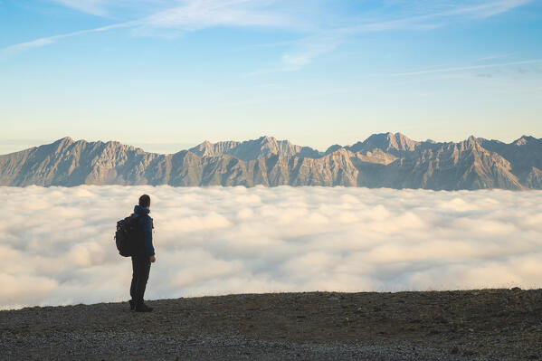 A mountaineer staring at the foggy Inn Valley with the Nordkette mountains in the background, Patscherkofel mountain, Innsbruck Land, Tyrol, Austria, Europe 