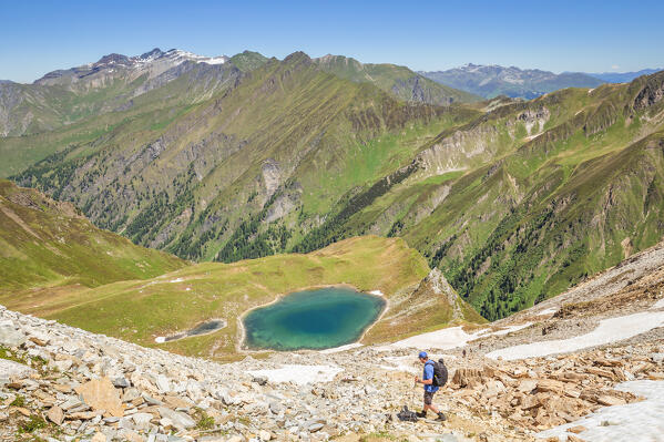 A mountaineer descending to Lake Ramsgrubner from the Schoeberspitzen mountains, Wildlahner, Schmirn Valley, Innsbruck Land, Tyrol, Austria, Europe