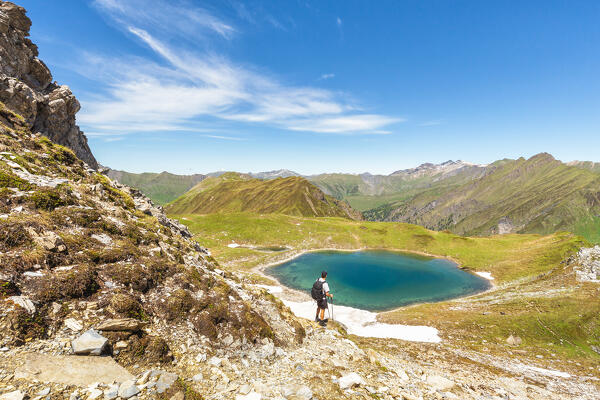 A mountaineer admiring Lake Ramsgrubner and the Tux alps on a summer day, Wildlahner, Schmirn Valley, Innsbruck Land, Tyrol, Austria, Europe