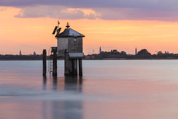 A weather station in the middle of the Venetian Lagoon at sunset, with the city of Venice in the background, Punta Sabbioni, Venice, Veneto, Italy, Europe 