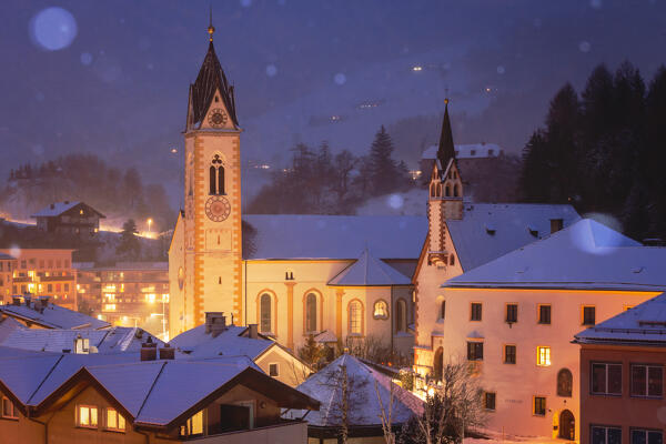 The snow falls at evening by the churches of Matrei am Brenner, Innsbruck Land, Tyrol, Austria, Europe