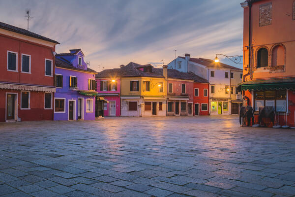 The iconic colored houses of Piazza Galuppi at dusk, Burano island, Venice, Veneto, Italy, Europe