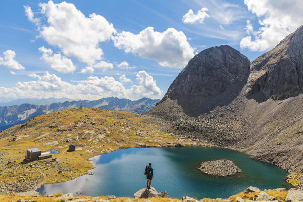 A hiker enjoying the view of Lake Sandessee - Lago di Sanes and of Rifugio Calciati al Tribulaun, Ladurns, Bolzano district, South Tyrol, Italy, Europe