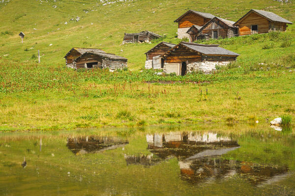 Old barns mirroring on a summer day, Lake Sennes, Fanes-Sennes-Braies Natural Park, Bolzano province, Trentino Alto Adige, Italy, Europe