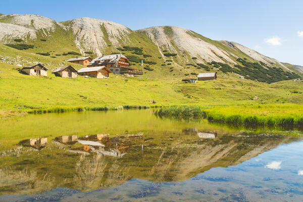 Rifugio Sennes and its barns mirrored by the little lake located directly by the mountain refuge, Fanes-Sennes-Braies natural park, Bolzano province, Trentino Alto Adige, Italy, Europe