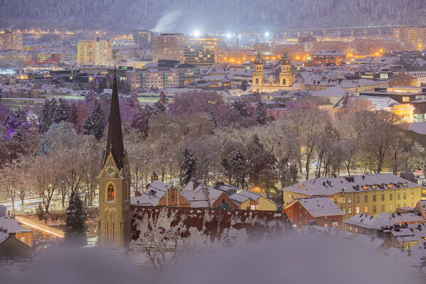 The view of the church of Sankt Nikolaus with the Court Garden and the city of Innsbruck in the background on a winter night, Innsbruck, Tyrol, Austria, Europe