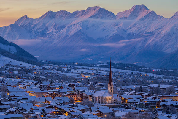 Dusk in the tyrolean village of Axams, as seen from the Panorama Weg hiking trail on a cold winter day, with the Mieming mountain range in the background, Axams, Westliches Mittelgebirge, Tyrol, Austria, Europe