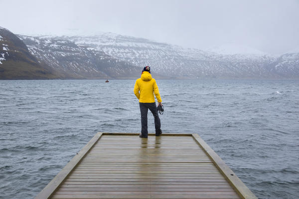 Photographer is looking the fjord at the Faroe Islands (Hosvik, Streymoy island, Faroe Islands, Denmark) (MR)