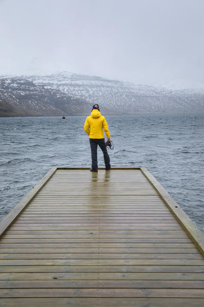 Photographer is looking the fjord at the Faroe Islands (Hosvik, Streymoy island, Faroe Islands, Denmark) (MR)