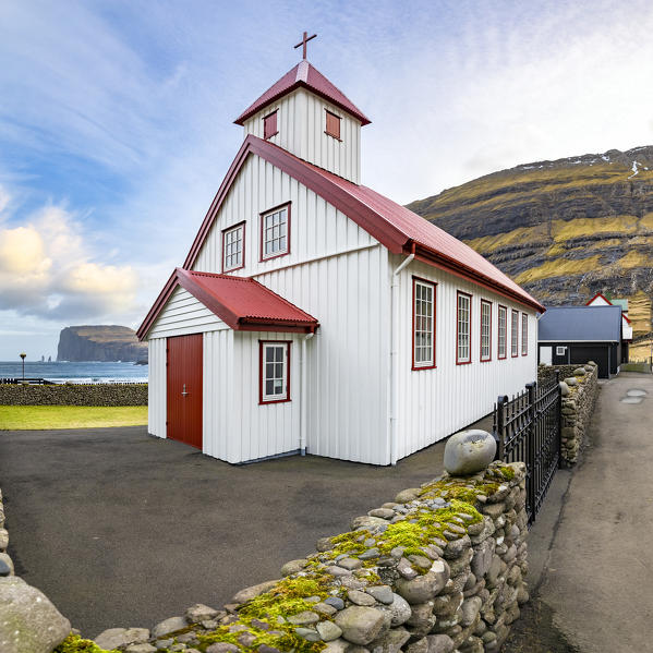 Tjornuvik Church and in background near the cliff the two sea stacks of Risin and Kellingin (Tjornuvik, Streymoy island, Faroe Islands, Denmark)