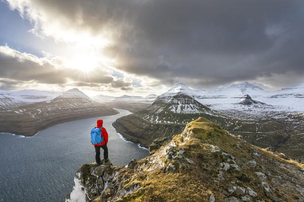 Hiker standing on peak over Funningur fjord (Eysturoy island, Faroe Islands, Denmark) (MR)