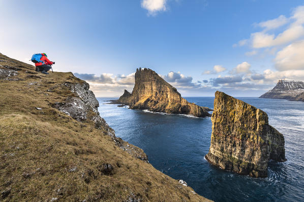 Photographer in front of the natural arch of Drangarnir and Tindholmur Islet (Vagar Island, Faroe Islands, Denmark) (MR)