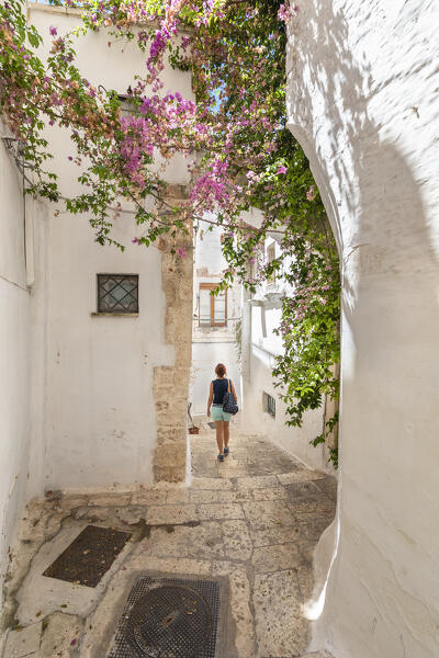 A woman is walking through the narrow alleys in the white village of Ostuni (province of Brindisi, Salento, Apulia, Italy) (MR)